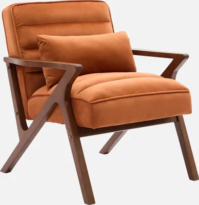 A single terrakotta colored armchair with wooden legs and frame, with a small pillow on it, against a white background.