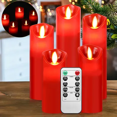A group of red LED candles with a remote control on a wooden surface, with a blurred background of lights and greenery.