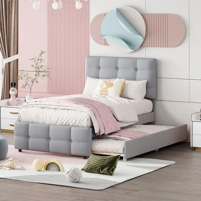 A child's bedroom with a grey upholstered bed and a pull-out trundle bed.