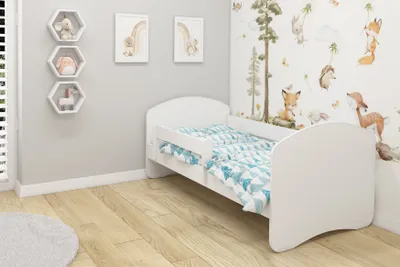 A child's bedroom with a white bed and animal-themed wallpaper.