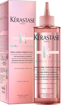 A product shot of a Kérastase hair treatment bottle and its packaging, set against a white background.