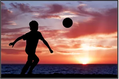 Produktbild von Wallario Wandbild Fußball - Kleiner Junge spielt im Abendrot, Größe: 61 x 91,50 cm, Poster mit schwarzem Aluminiumrahmen