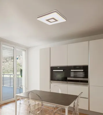 A modern kitchen or dining area with a table and chairs, and built-in ovens.
