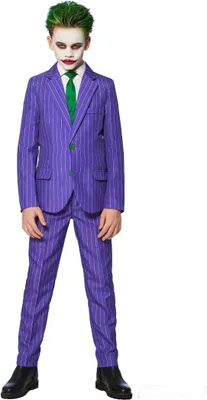 A young boy dressed as the Joker stands against a white background.