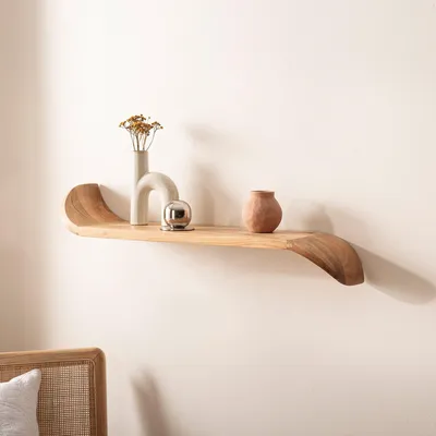 A wooden shelf with decorative items mounted on a white wall.