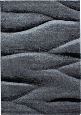 A close-up, abstract view of a textured rug with wavy patterns.