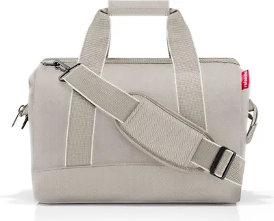 A beige duffel bag with a shoulder strap is shown against a white background.
