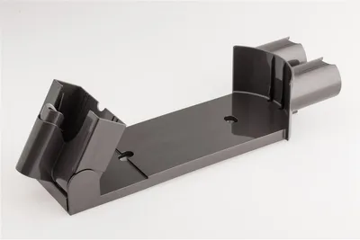 A gray Dyson vacuum cleaner wall mount on a white background.