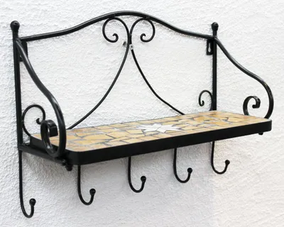 A black metal wall shelf with a mosaic tiled surface and four hooks underneath, mounted on a white wall.