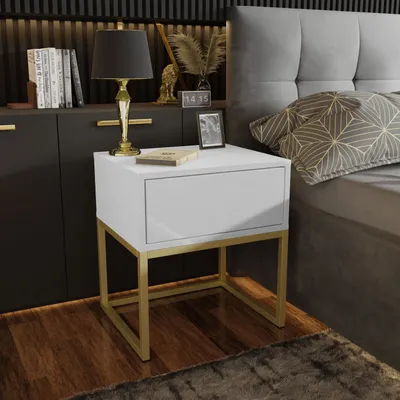 A modern bedroom scene featuring a white nightstand with a gold frame next to a bed.