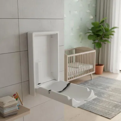 Eine weiße, vertikale Wickelstation, an der Wand eines Babyzimmers montiert. Im Hintergrund sind ein Kinderbett und eine mintgrüne Mustertapete zu sehen.