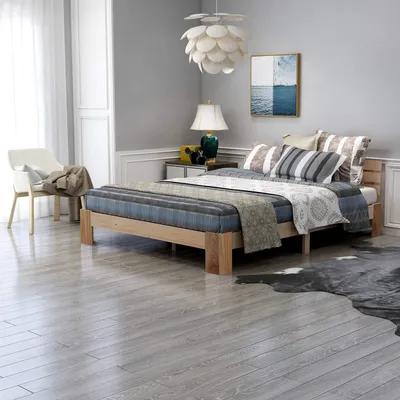 A bedroom scene with a bed, chair, and decor.