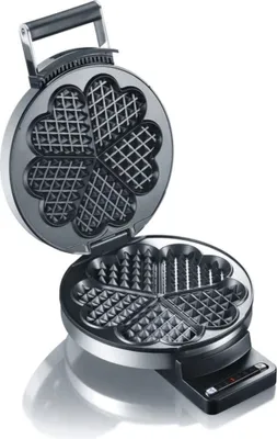 An open waffle iron with heart-shaped molds.