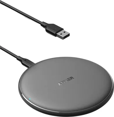A black wireless charging pad with a USB cable on a white background.