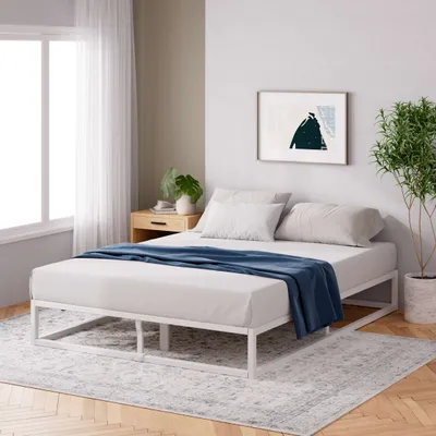 Weißer Metallbettrahmen mit Matratze in modernem Schlafzimmer mit Teppich und Tageslicht.
