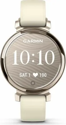 A close-up studio shot of a Garmin Lily 2 smartwatch with a cream and gold finish, displaying the time and date on its screen.