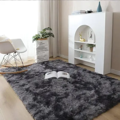 A cozy living room scene with a shaggy rug, rocking chair, and bookshelf.