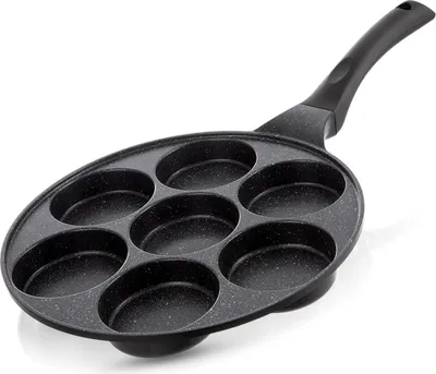 A black frying pan with seven circular indentations for cooking small items like pancakes or eggs.