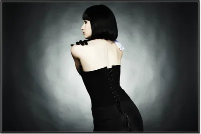 Produktbild von Wallario Wandbild Schöne Frau im schwarzen Kleid zeigt ihren Rücken, Größe: 61 x 91,50 cm, Poster mit schwarzem Aluminiumrahmen