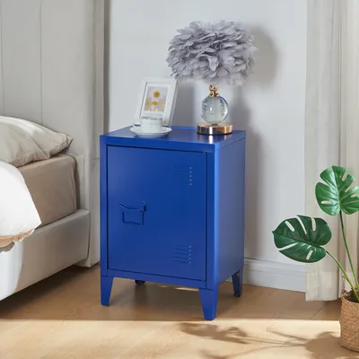 A blue metal nightstand next to a bed, with a lamp and a framed picture on top.