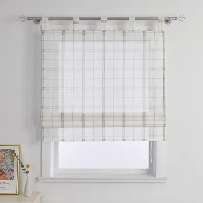A plaid roman blind hanging in a window, with a framed picture and a vase with a flower on a surface below.