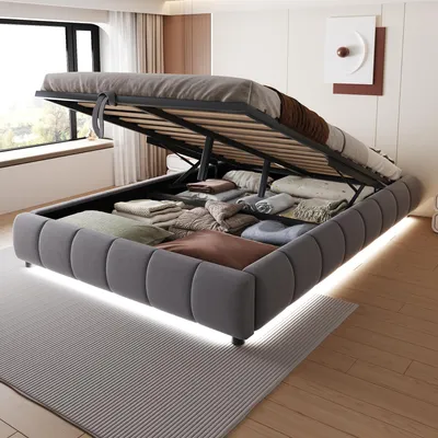 A bed with its storage compartment open, revealing neatly folded linens and blankets. The bed is in a bedroom setting with a window and a rug.