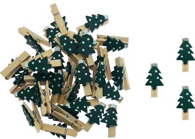 A pile of small wooden clothespins decorated with green Christmas trees with white dots, on a white background.