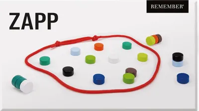 A collection of colorful magnetic pieces arranged on a white surface, with a red cord forming a loop around some of them. The product name 'ZAPP' is displayed prominently in the top left corner.