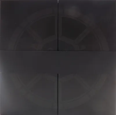A dark, abstract pattern resembling a gear or wheel is visible on a black background, divided into four quadrants.