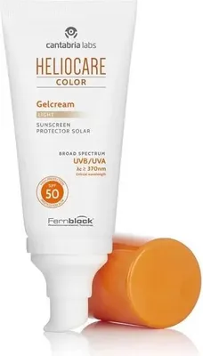 A tube of sunscreen with its cap off, resting on a reflective surface.