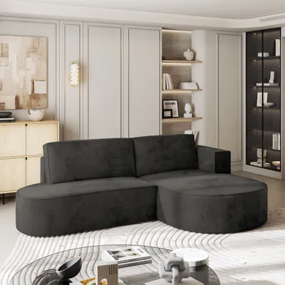 A modern living room with a dark gray sectional sofa, built-in shelving, and a glass coffee table.