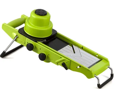 A bright green mandoline slicer is shown against a white background.