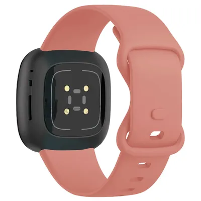The back of a pink Fitbit Versa 4 smartwatch band with the watch body attached.