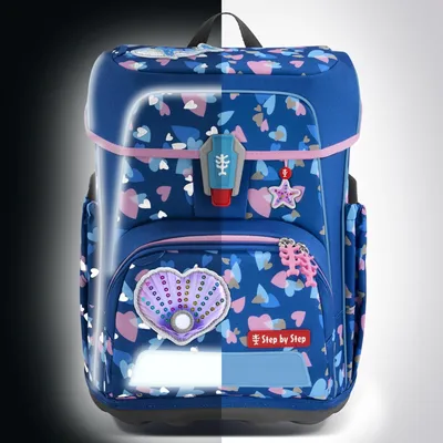 A blue backpack with a heart and star pattern, featuring reflective elements on a split black and white background.