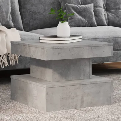 A modern living room setting with a gray couch and a concrete-style coffee table.