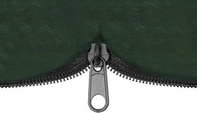 A close-up of a dark green zipper on a fabric surface, partially open.