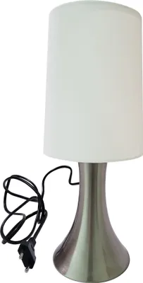 A table lamp with a white shade and a silver base, shown on a white background with its black power cord.