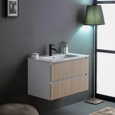 A modern bathroom vanity with a sink and faucet, illuminated by a floor lamp.