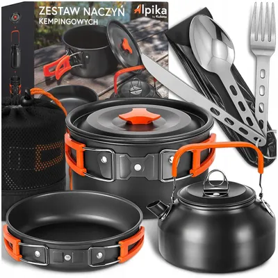 A collection of camping cookware and utensils laid out on a wooden surface, with a box in the background.
