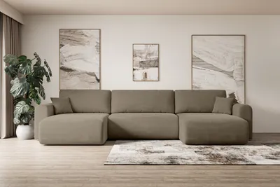 A spacious living room with a large sectional sofa, artwork, and a potted plant.