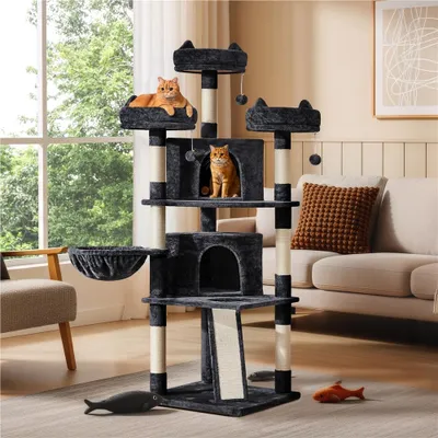 A multi-level cat tree with two cats, placed in a living room setting with a couch and window in the background.