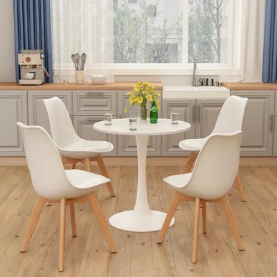 A white tulip-style dining table with four white chairs in a kitchen setting.