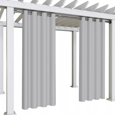 Two light gray outdoor curtains hanging from a white pergola.