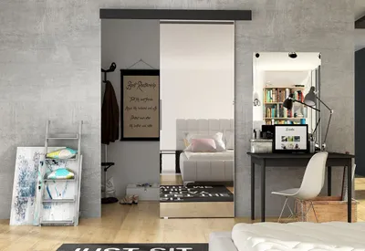 A modern bedroom with a sliding mirror door, a desk with a laptop, and decorative items.