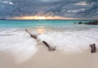 Produktbild von Wallario Fototapete Vliestapete, seidenmatte Oberfläche, einfache Verarbeitung, Größe 200 x 140 cm, Motiv Wellen am Strand bei Sonnenuntergang