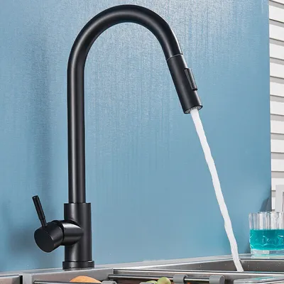 A black kitchen faucet with water running into a sink.