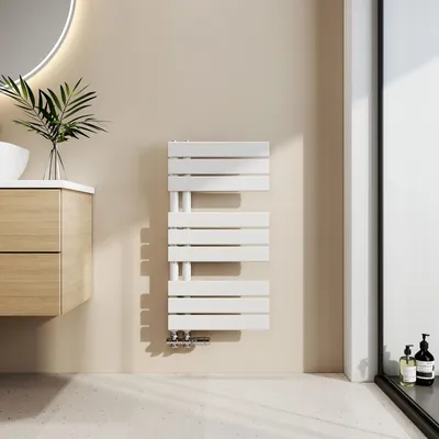 A modern bathroom setting with a white towel radiator mounted on a light beige wall.
