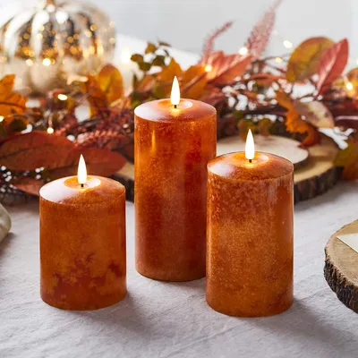 Produktbild von Lights4fun 3er Set Echtwachs TruGlow® Kerzen orange mit warmweißer LED Flamme und Timer 10/12,5 / 15cm