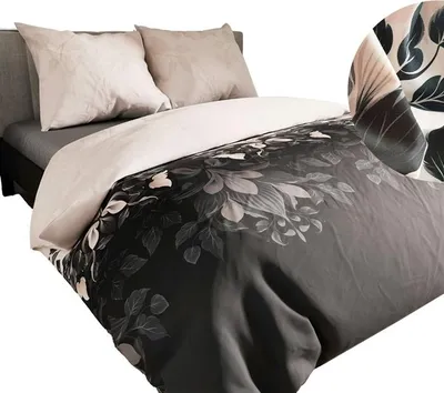 A close-up view of a bed with a duvet cover featuring a dark floral pattern and two beige pillows.