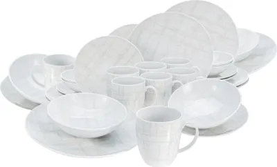 A collection of white porcelain dinnerware with a subtle gray plaid pattern, arranged in a studio setting.